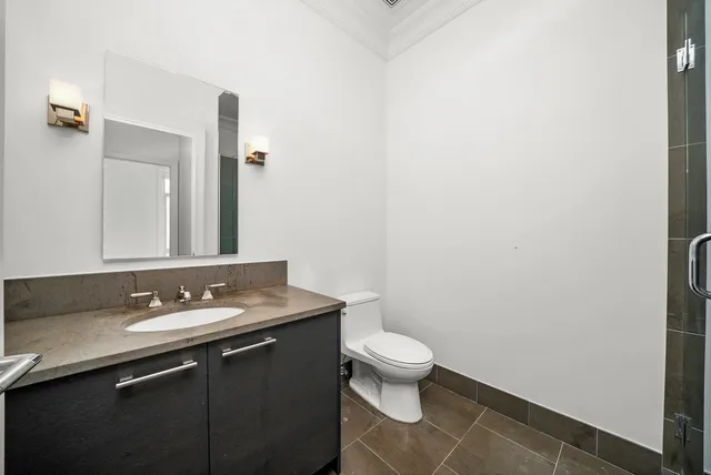 a bathroom with a granite countertop sink a toilet and a mirror