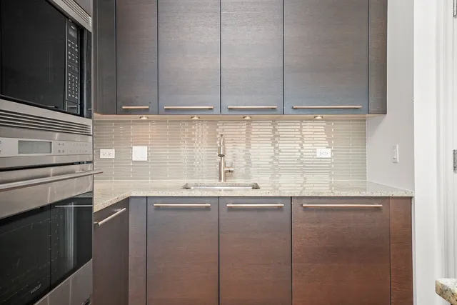 a kitchen with stainless steel appliances granite countertop a sink and a microwave
