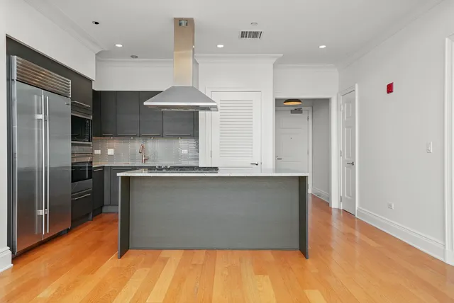 a kitchen with stainless steel appliances granite countertop a refrigerator a sink and a stove