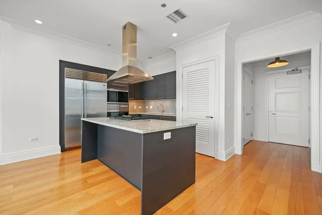 a kitchen with stainless steel appliances granite countertop a sink counter space and wooden floor