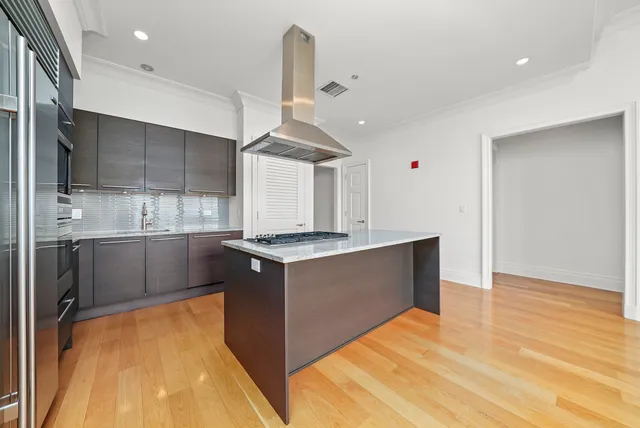 a kitchen with stainless steel appliances granite countertop a sink a stove and a refrigerator