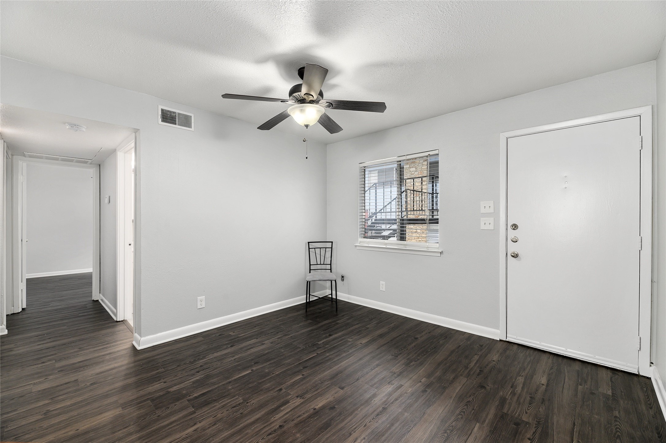 2408 Longview Street, Unit 113 Austin, TX 78705 - Photo 22 of 23 Foyer with dark wood-type flooring, a textured ceiling, and a ceiling fan