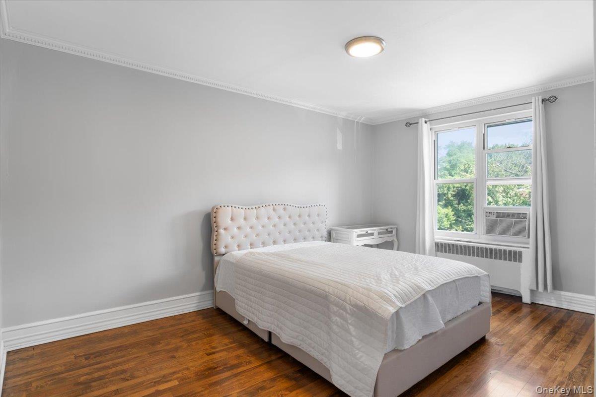 77 Edwards Street, Unit 2A Roslyn Heights, NY 11577 - Photo 11 of 29 a bedroom with a bed and a large window