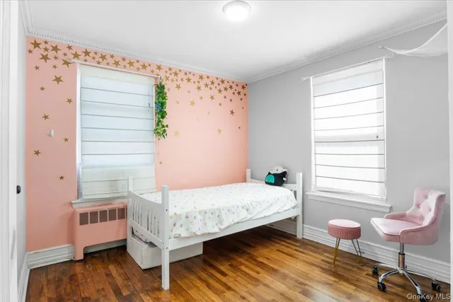 a bedroom with a bed wooden floor and window