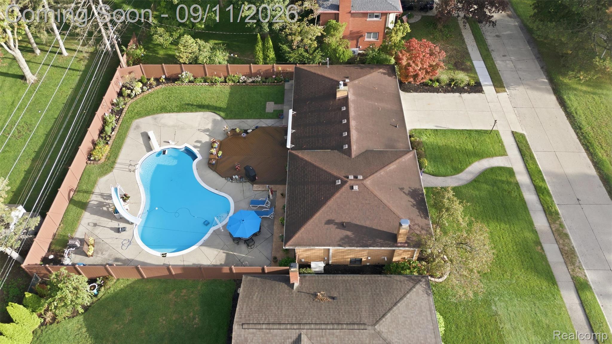 16799 Farmington Road Livonia, MI 48154 - Photo 59 of 71 Fenced backyard with an in-ground pool, concrete patio, and mature landscaping