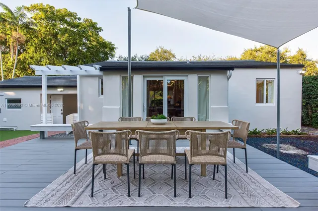a kitchen with stainless steel appliances granite countertop a table chairs sink and cabinets