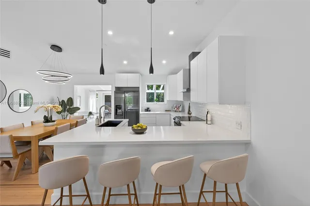 a kitchen with stainless steel appliances granite countertop a sink a center island and cabinets