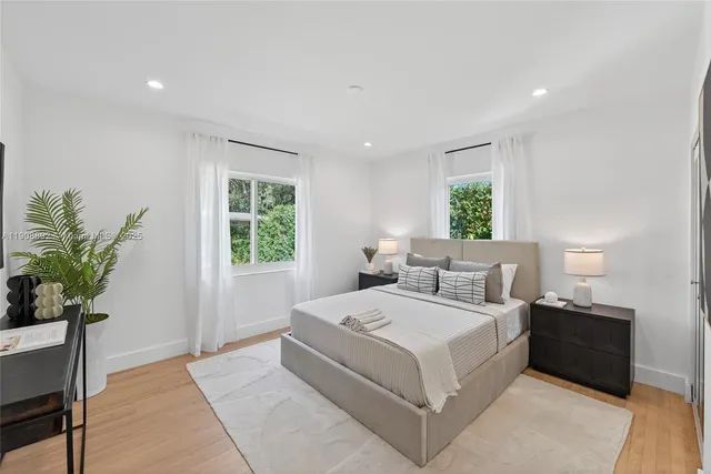 a bedroom with a large bed and a painting on the wall