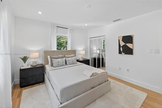 a large bed sitting in a bedroom next to a window