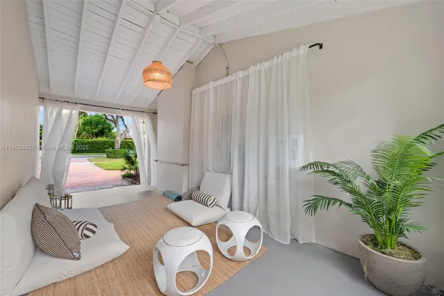 a living room with furniture floor to ceiling window and a flat screen tv