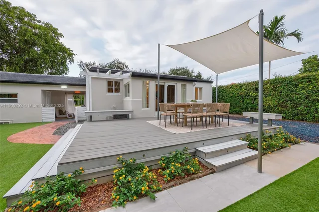 a view of a house with backyard and sitting area