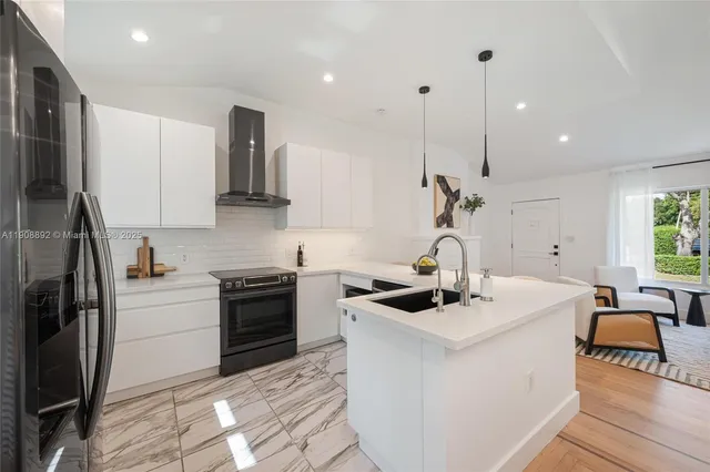 a kitchen that has a sink a stove and a refrigerator