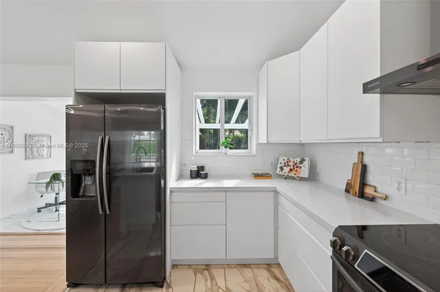 a kitchen with a refrigerator sink and cabinets