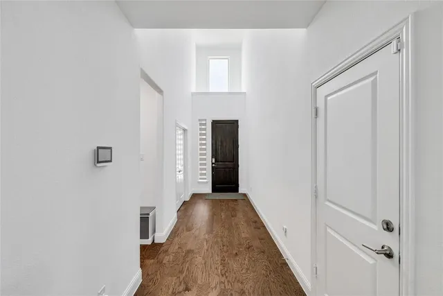 a view of a hallway with wooden floor and staircase