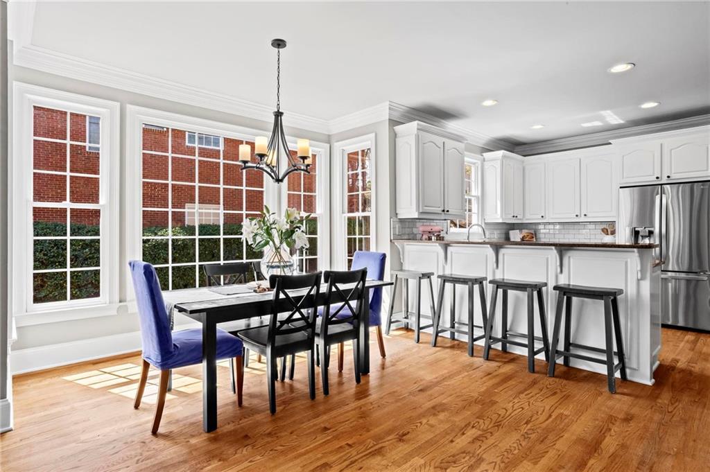 14375 Morning Mountain Way Milton, GA 30004 - Photo 15 of 53 a dining room with stainless steel appliances granite countertop a dining table chairs and large windows