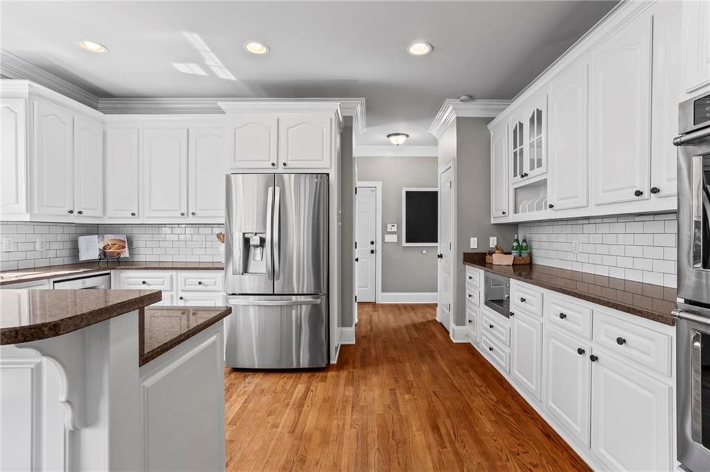 14375 Morning Mountain Way Milton, GA 30004 - Photo 18 of 53 a kitchen with granite countertop appliances a sink cabinets and wooden floor