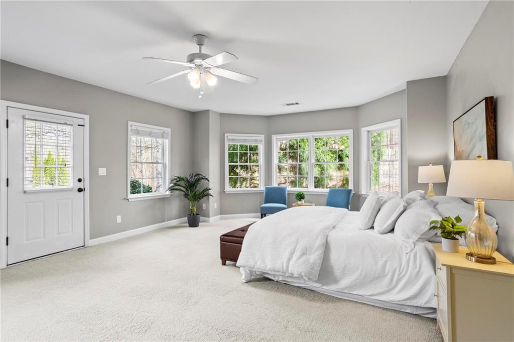 14375 Morning Mountain Way Milton, GA 30004 - Photo 42 of 53 a bedroom with a large bed and a chandelier fan