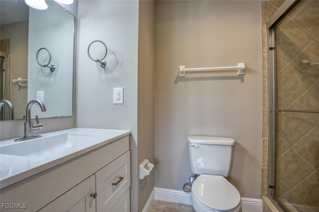 5917 Littlestone Court, Unit 118 North Fort Myers, FL 33903 - Photo 12 of 20 a bathroom with a toilet sink vanity and mirror