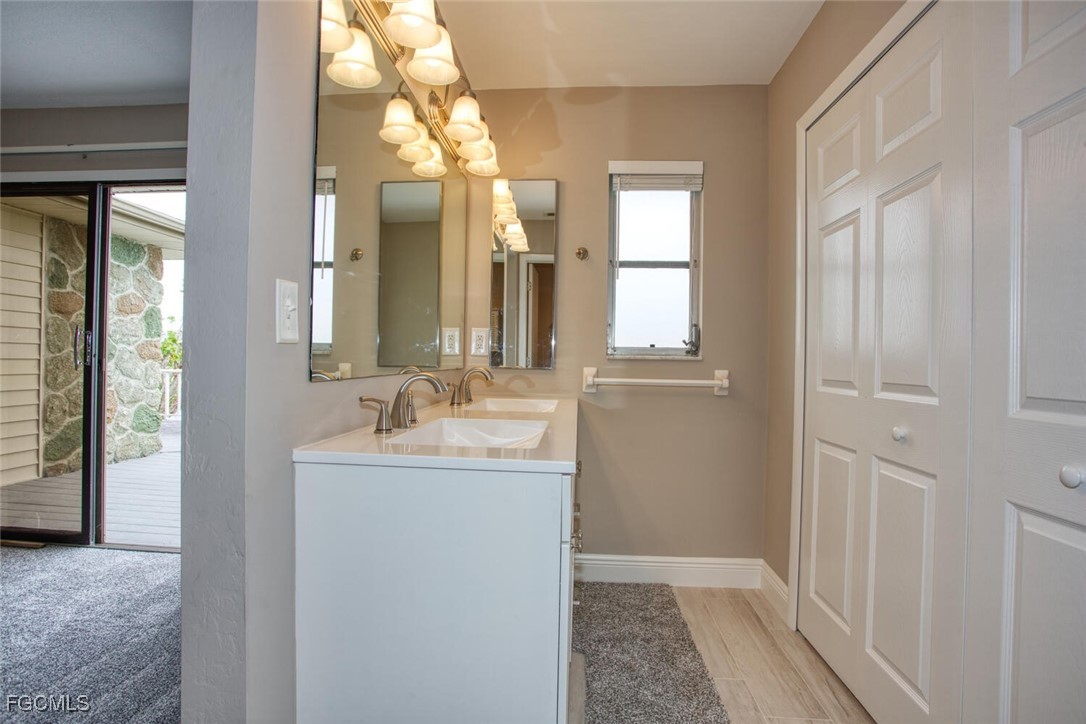5917 Littlestone Court, Unit 118 North Fort Myers, FL 33903 - Photo 16 of 20 a en suite bathroom with a granite countertop sink and a mirror