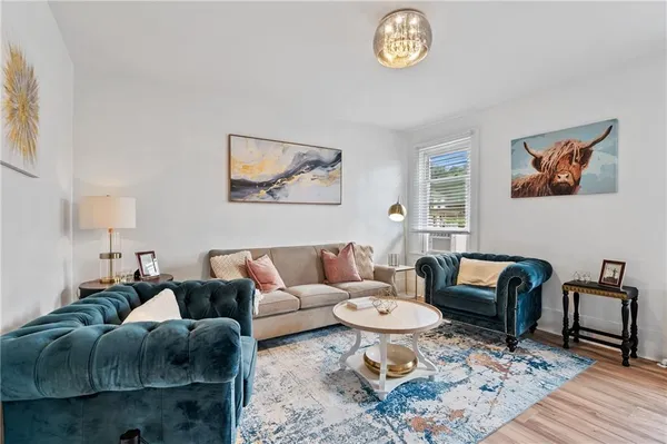 a living room with furniture a rug and a window