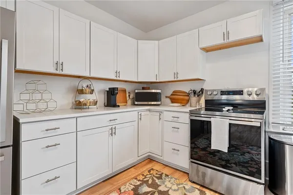a kitchen with white cabinets and appliances
