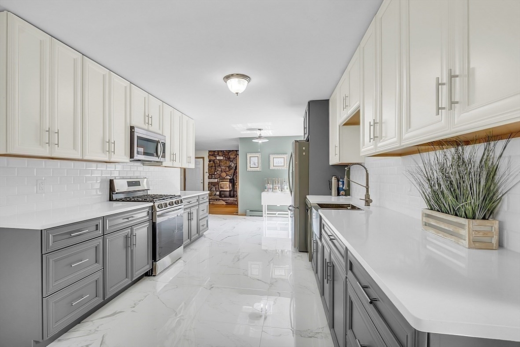 73 Off Ruggles Street Gilbertville, MA 01031 - Photo 7 of 38 a kitchen with stainless steel appliances granite countertop a sink and dishwasher a stove top oven with white cabinets