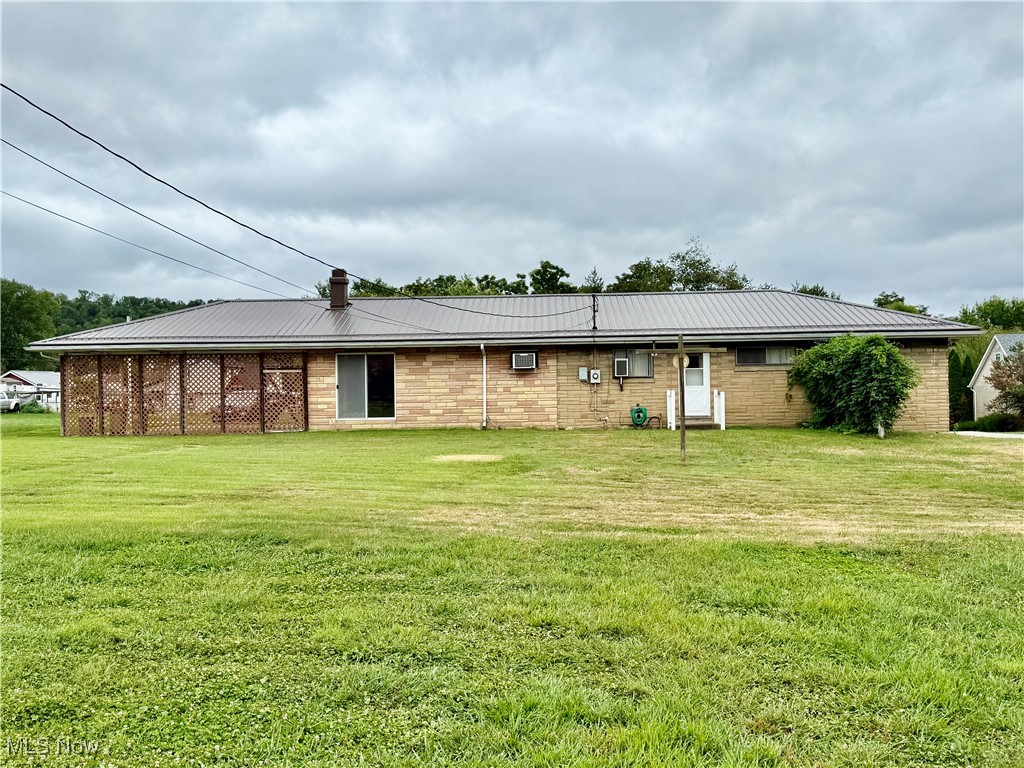 923 Archer Hill Road Colliers, WV 26035 - Photo 31 of 33 Back of house with brick siding, a yard, and a metal roof
