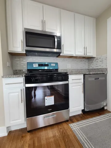 a kitchen with stainless steel appliances granite countertop a stove a microwave and cabinets