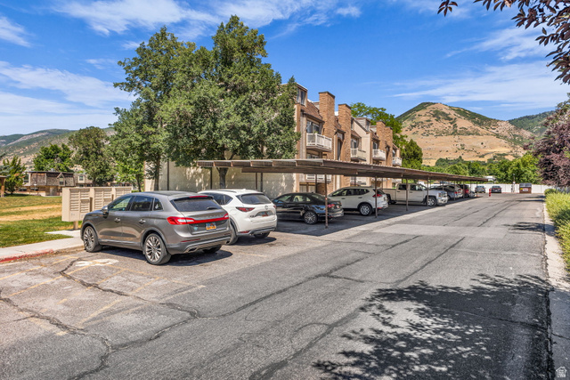 88 West 50 South, Unit C8 Centerville, UT 84014 - Photo 28 of 29 Paved parking area featuring a multi-car carport structure with mountain scenery in the background