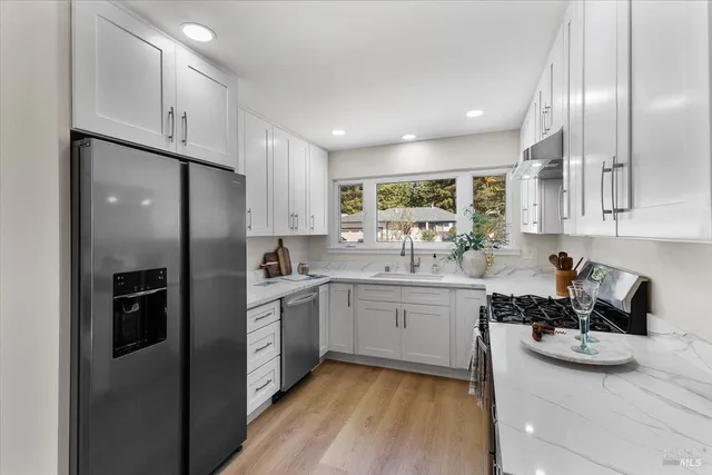 a kitchen with white cabinets and stainless steel appliances