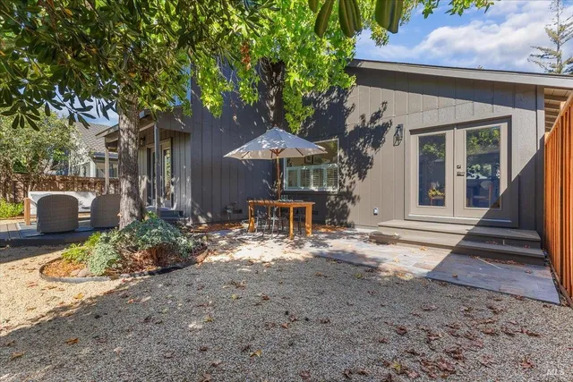 a view of a backyard with potted plants and large tree