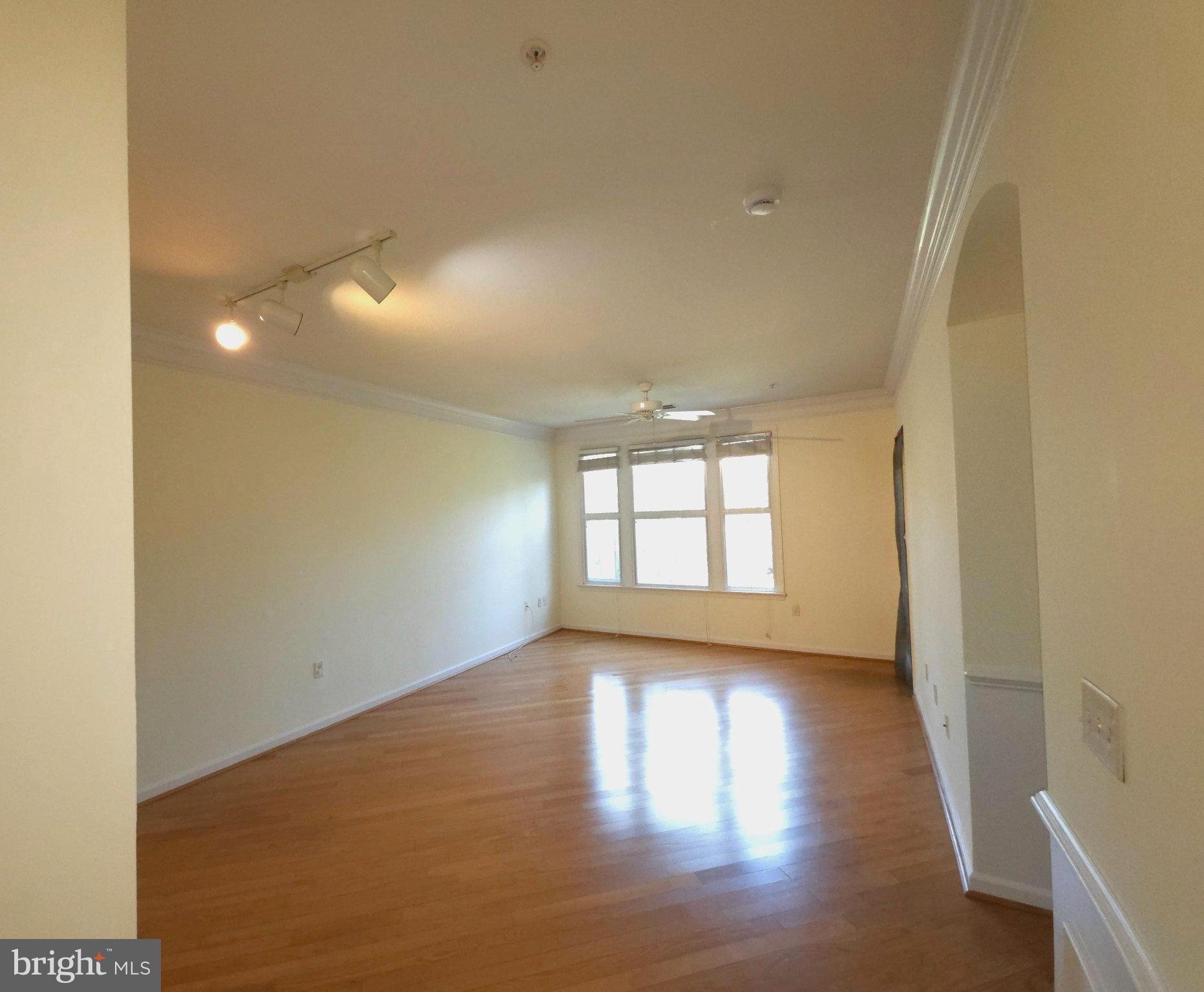 7 Booth Street, Unit 308 Gaithersburg, MD 20878 - Photo 4 of 21 an empty room with wooden floor and windows