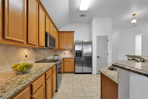 a kitchen with stainless steel appliances granite countertop a sink stove and refrigerator