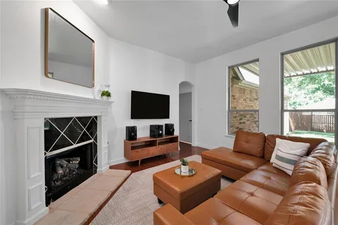 a living room with furniture a flat screen tv and a fireplace