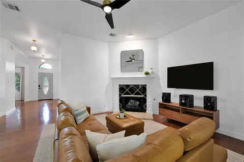 a living room with furniture a flat screen tv and a fireplace