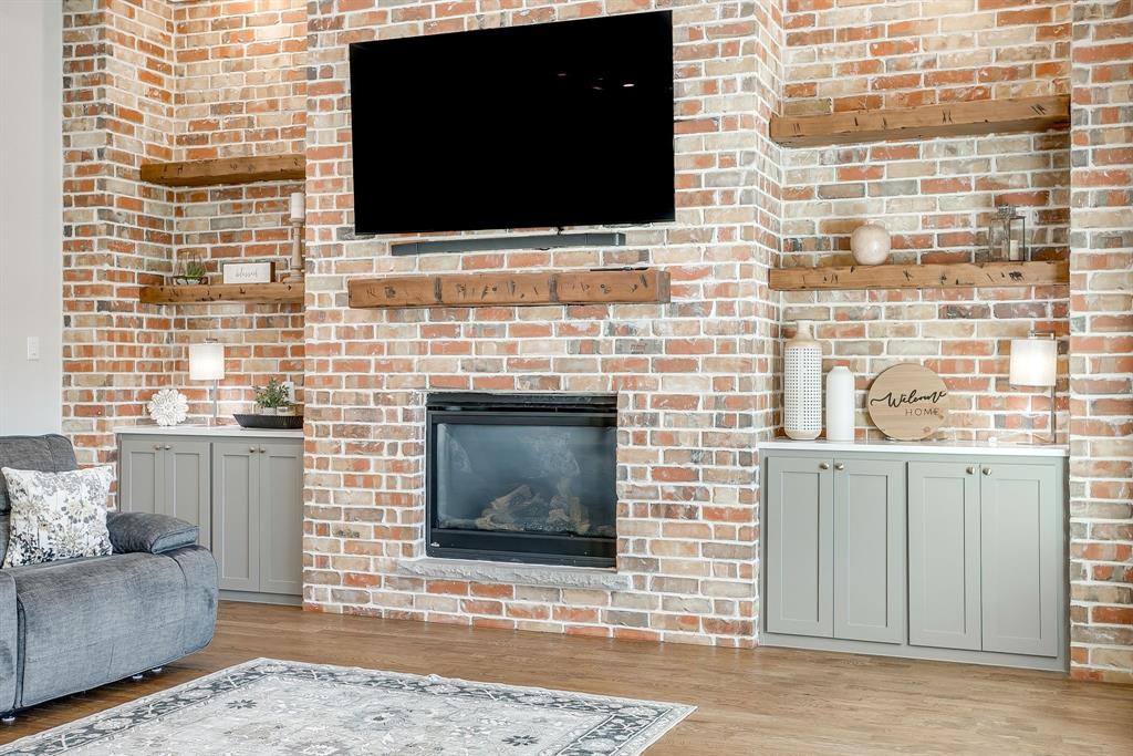 13921 Riviera East Fort Worth, TX 76028 - Photo 11 of 40 a living room with a fireplace and a flat screen tv