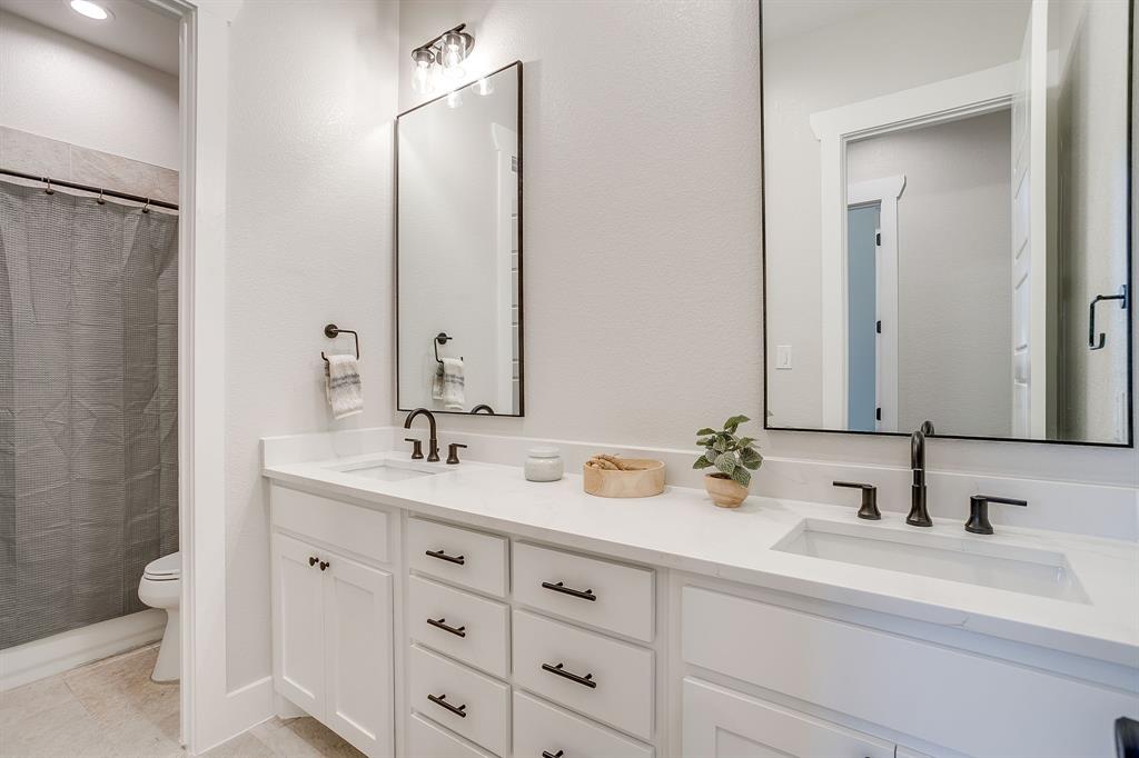 13921 Riviera East Fort Worth, TX 76028 - Photo 30 of 40 a bathroom with double sink and a mirror