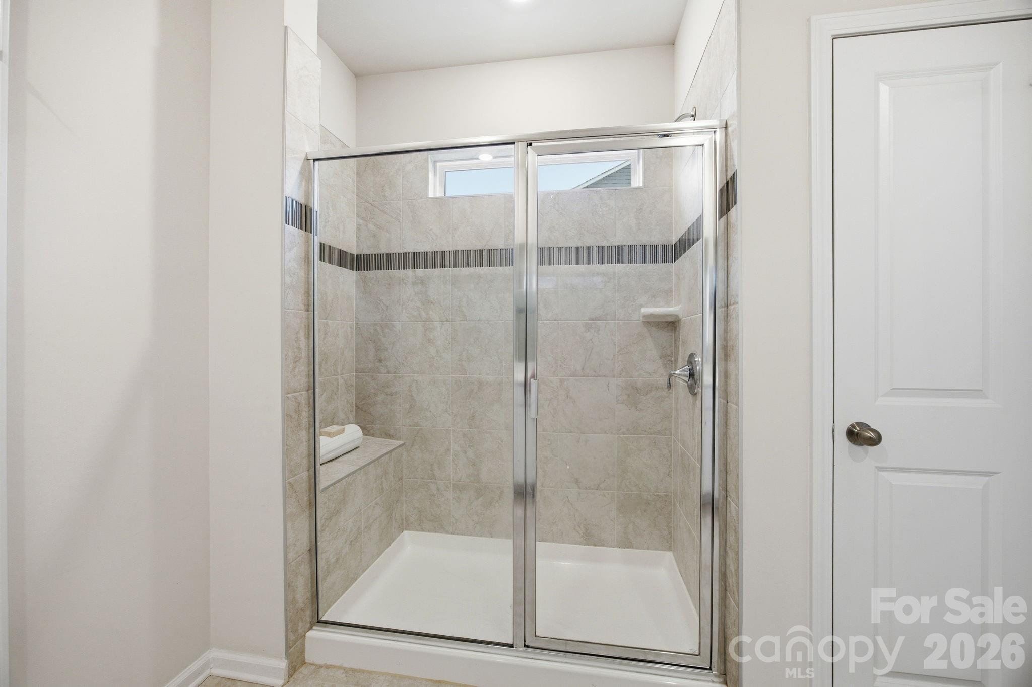 234 Hamptons Cove Road Troutman, NC 28166 - Photo 17 of 32 a bathroom with a glass shower door