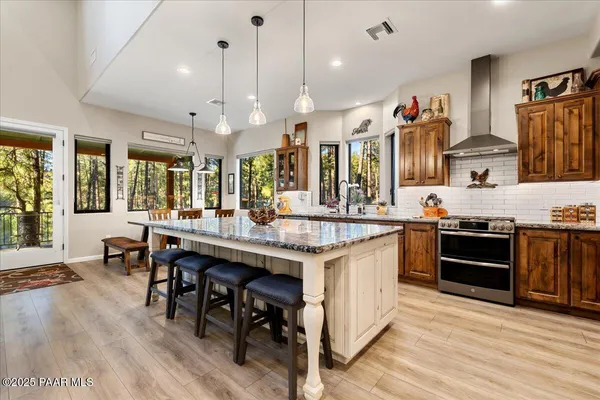 a large kitchen with stainless steel appliances kitchen island granite countertop a large counter top a stove a sink and a refrigerator