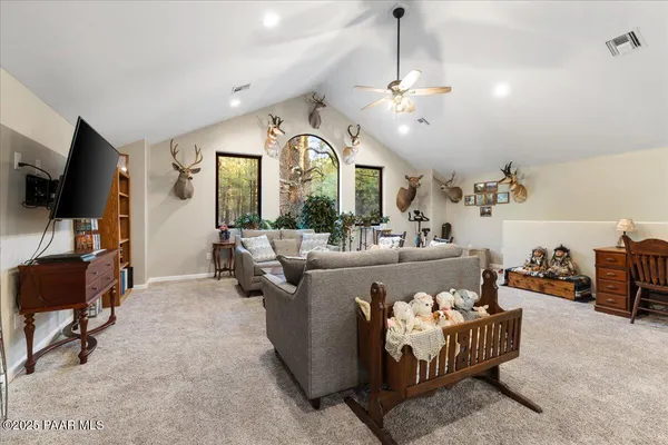 a living room with furniture a chandelier and a flat screen tv