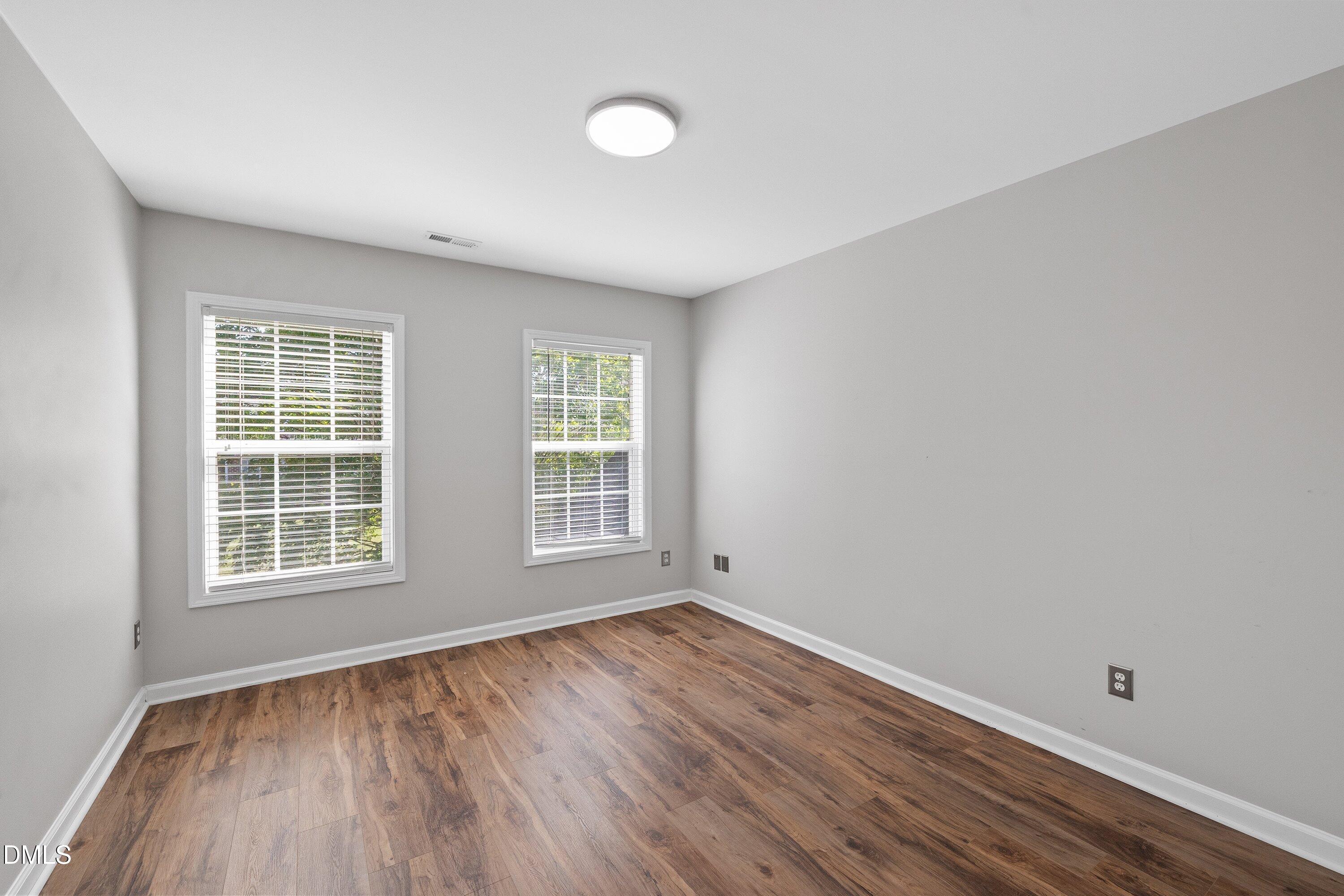 3717 Windmeade Road Wake Forest, NC 27587 - Photo 36 of 51 an empty room with wooden floor and windows