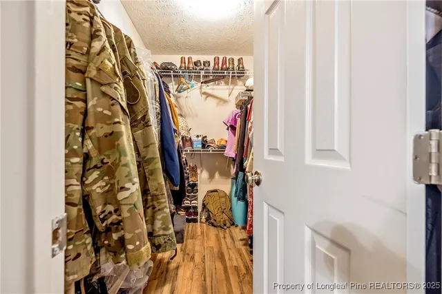 a view of walk in closet with clothes