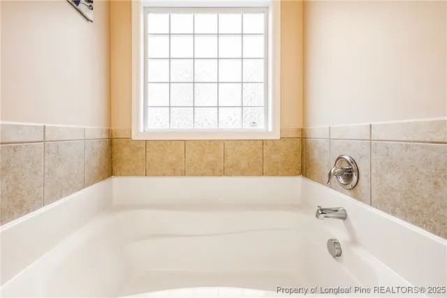 a white bath tub sitting in a bathroom next to a window