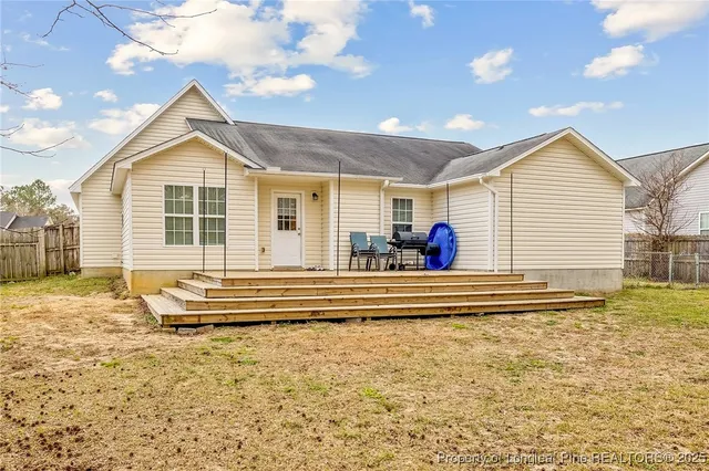 a view of a house with a backyard and a tree