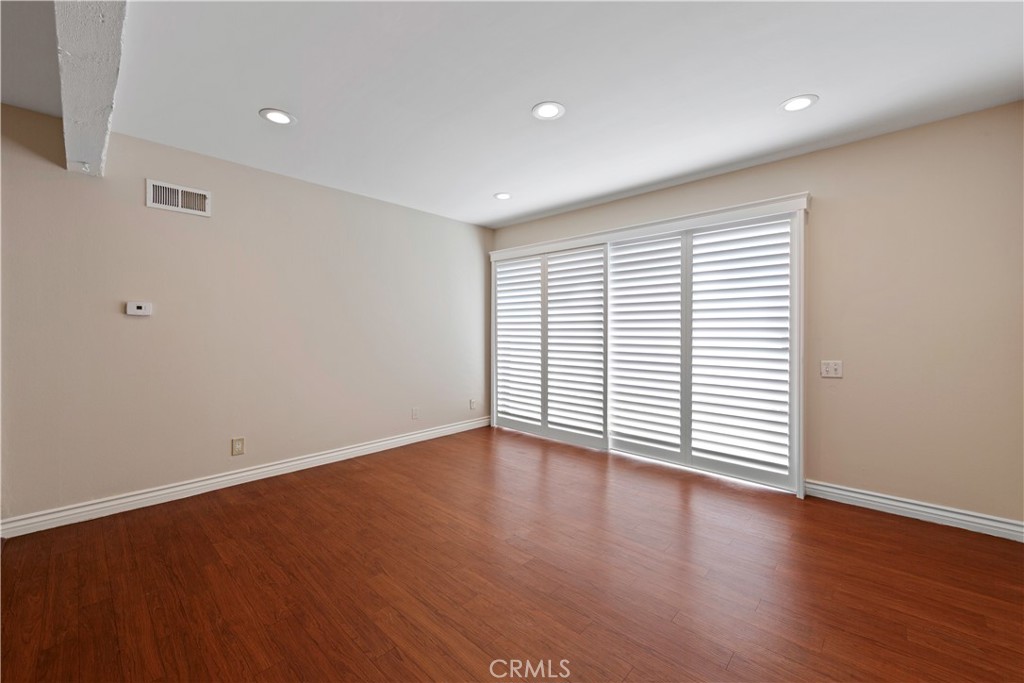 a view of a room with wooden floor and window
