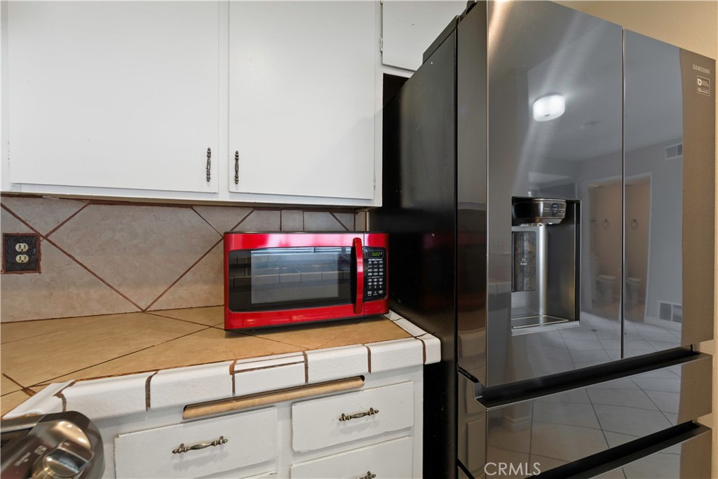 1381 South Walnut Street, Unit 2008 Anaheim, CA 92802 - Photo 11 of 40 a kitchen with white cabinets and a refrigerator