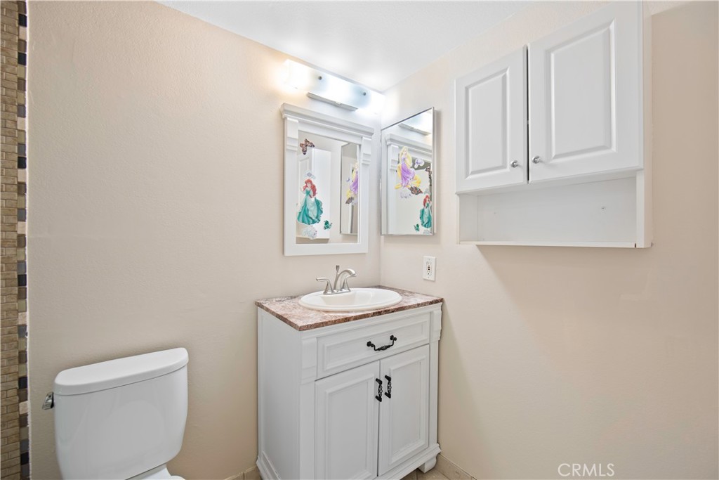 1381 South Walnut Street, Unit 2008 Anaheim, CA 92802 - Photo 29 of 40 a bathroom with a sink a toilet and painting on the wall