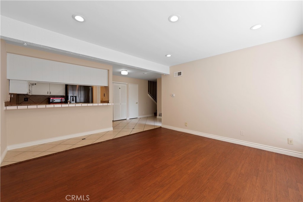 1381 South Walnut Street, Unit 2008 Anaheim, CA 92802 - Photo 5 of 40 an empty room with wooden floor and kitchen