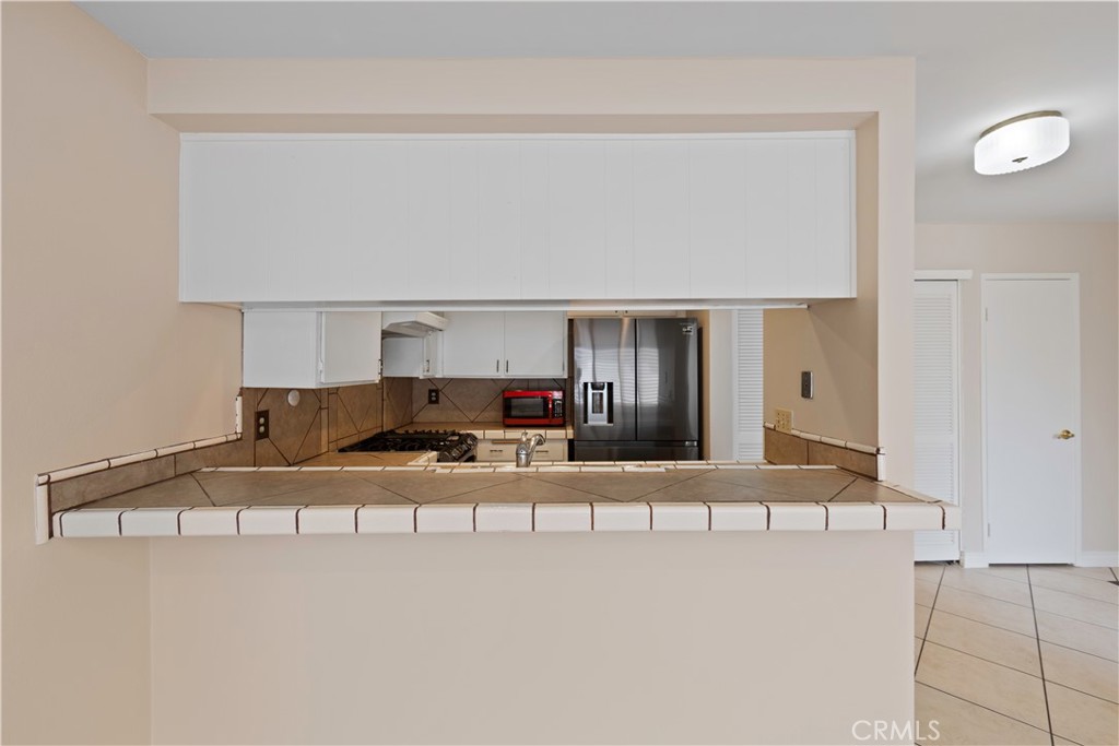 1381 South Walnut Street, Unit 2008 Anaheim, CA 92802 - Photo 6 of 40 a kitchen with kitchen island cabinets and refrigerator