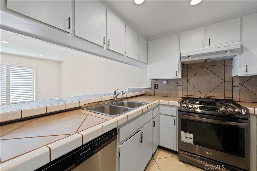1381 South Walnut Street, Unit 2008 Anaheim, CA 92802 - Photo 9 of 40 a kitchen with a sink stove top oven and cabinets